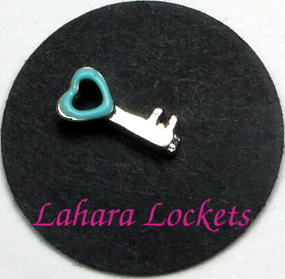 This floating charm is a silver key with teal, heart shaped head.